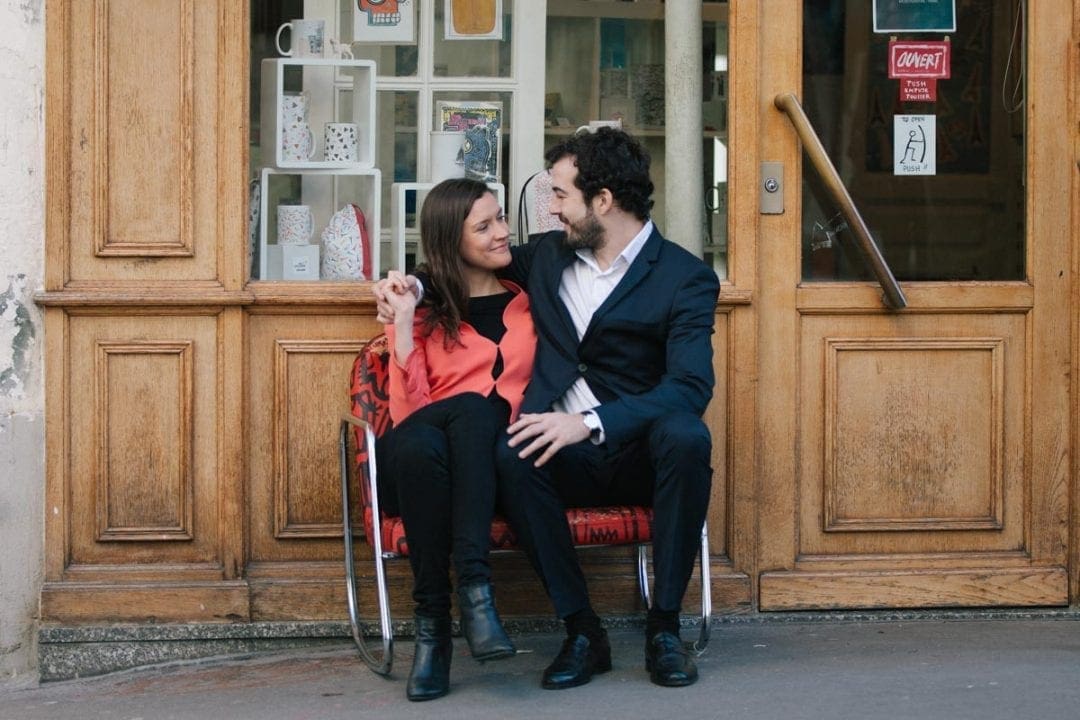 Couple sitting on a bench on a cobbled street in Paris