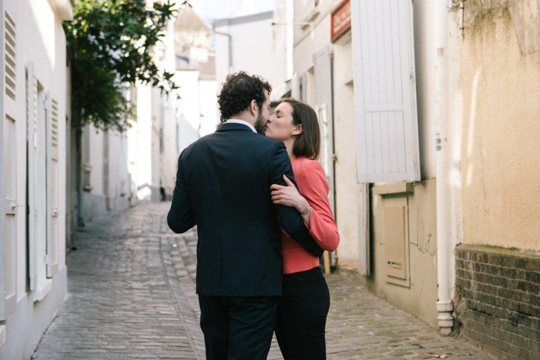 Couple kissing on a cobbled street in Montmartre, Paris