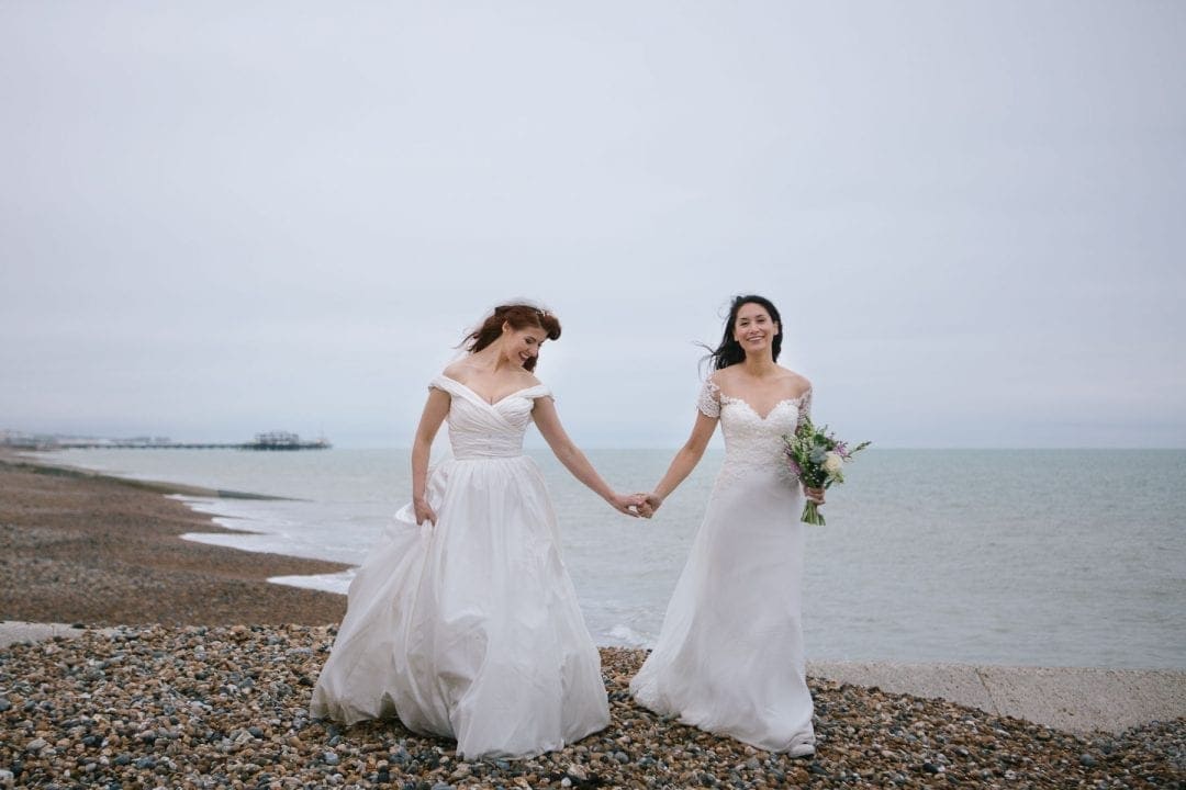 lesbian brides in on Brighton Beach holding hands