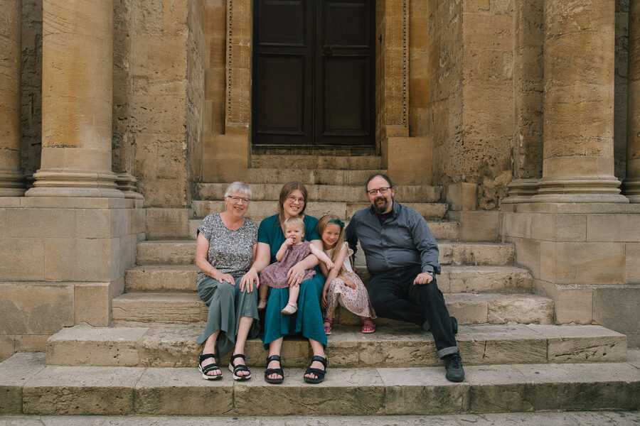 Family sitting on ancient stone steps outdoors