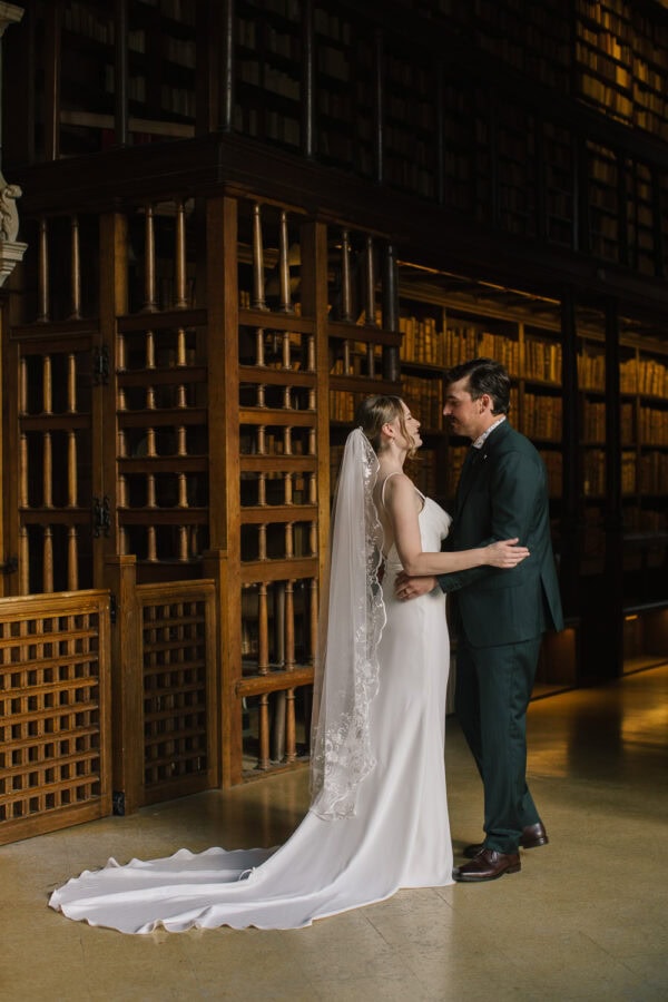 First kiss in the Bodleian Library’s Duke Humfrey’s reading room, shelves of historic volumes all around