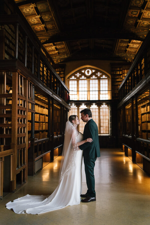 Elopement ceremony inside Duke Humfrey’s Library at the Bodleian Library, framed by centuries-old books and warm wood tones.