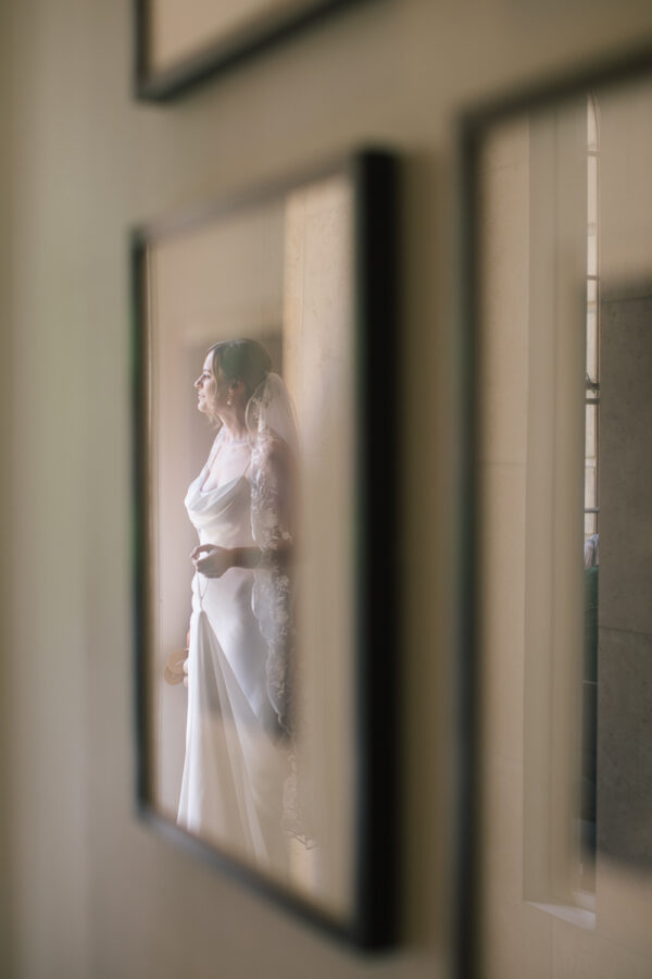 Bride’s reflection captured in a window at the Old Bank Hotel in Oxford — soft, modern, timeless