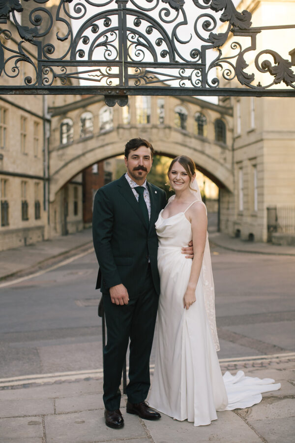 Newlyweds framed perfectly beneath the arch of the Bridge of Sighs in Oxford