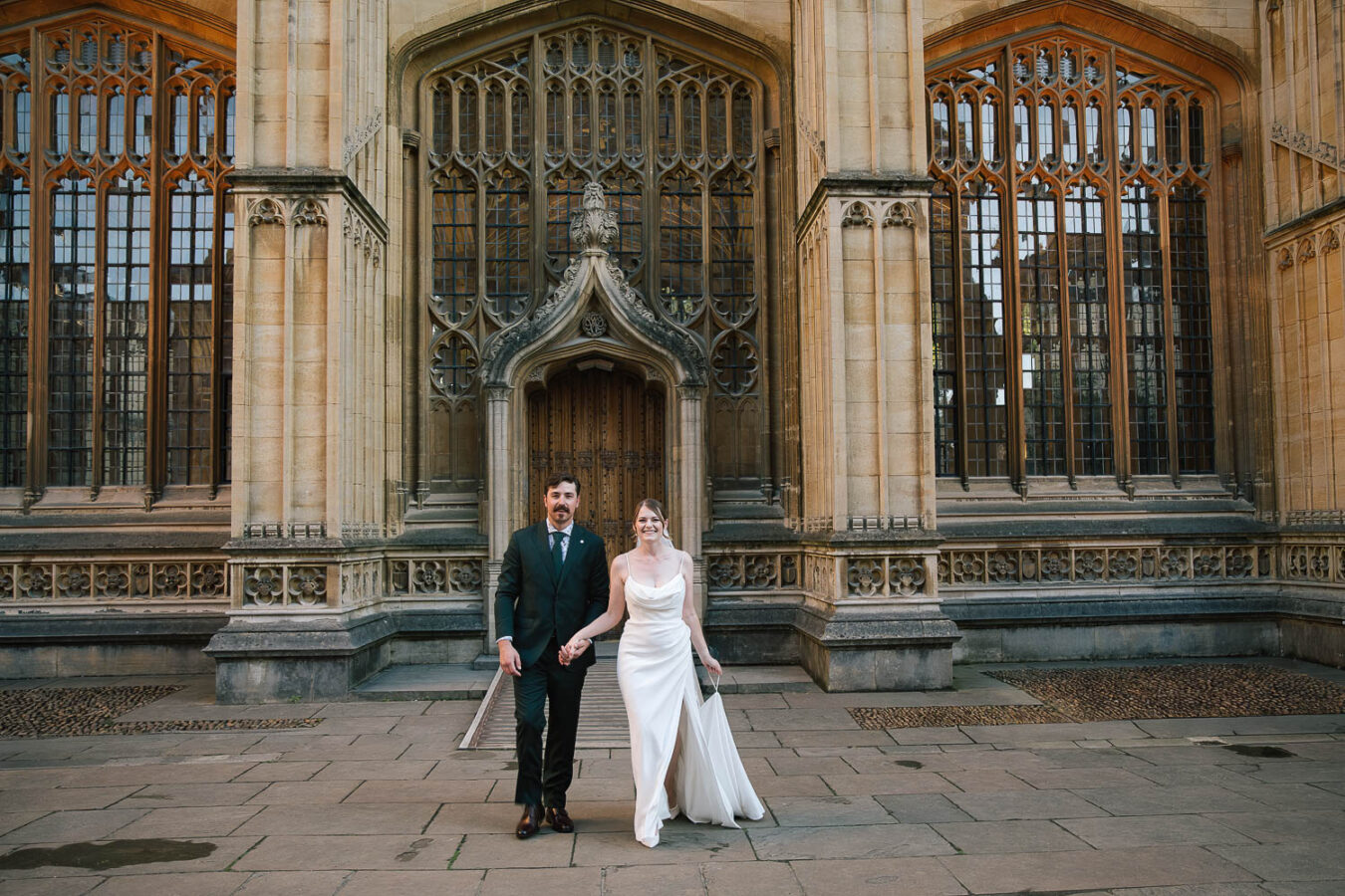 Bride and groom standing outside the Bodleian Library in Oxford,
