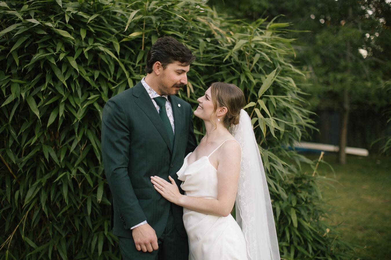 Romantic portrait of the couple nestled among tall trees at the Cherwell Boathouse, Oxford