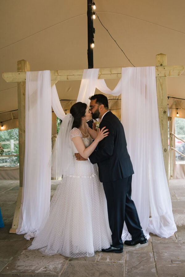 bride and groom kiss at alter at tipi wedding