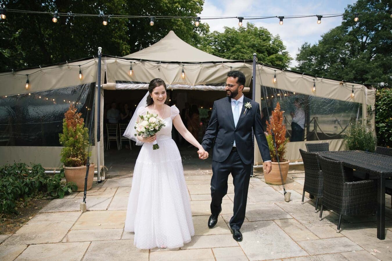bride and groom walking out of tipi tent